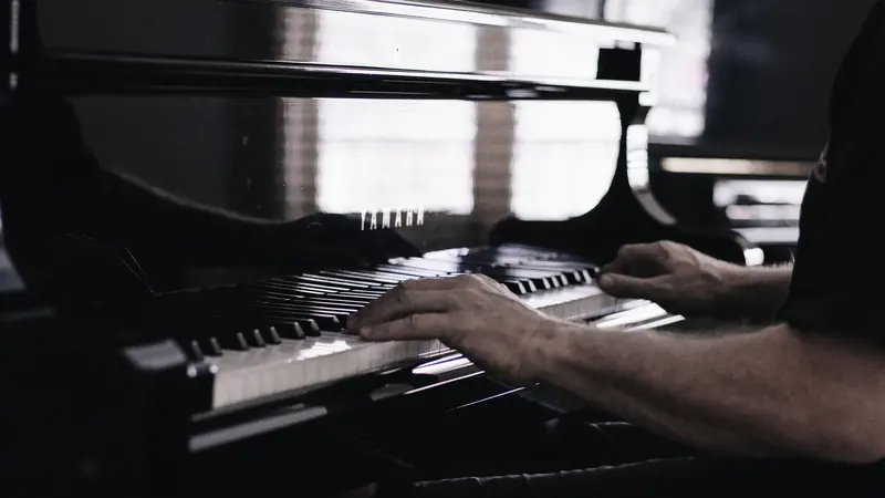 Pianiste au piano à queue, reflet des mains sur la laque noire