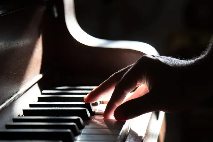 Accords au piano — main jouant un accord dans une lumière douce