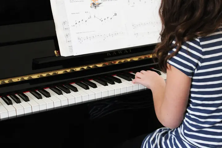 Improviser au Piano : Guide pour Debutants — élève travaillant ses accords au piano droit