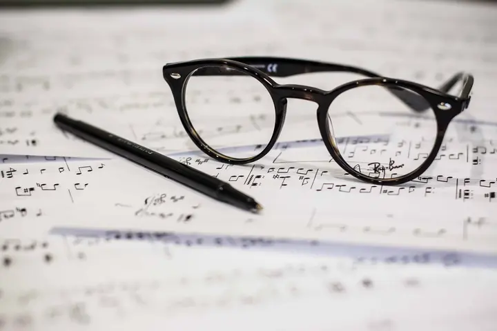 Accords au piano — feuille de musique, stylo et lunettes sur un bureau